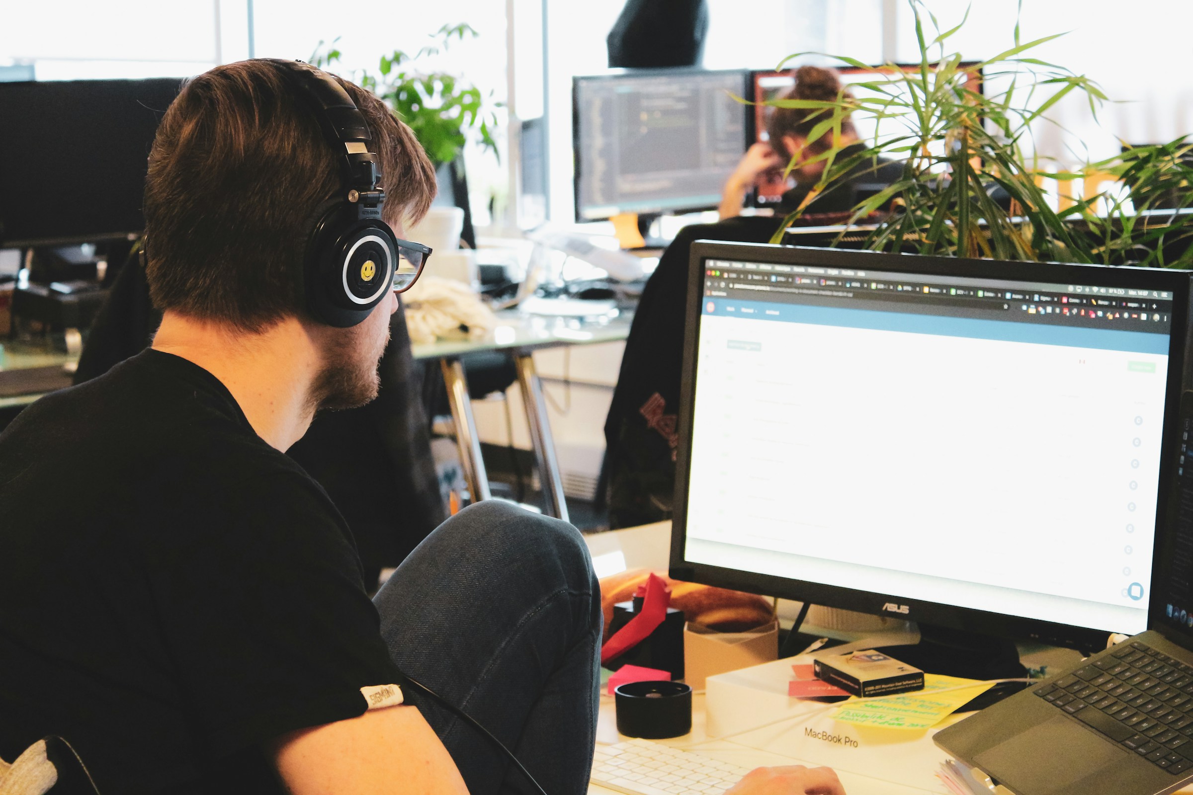 IT-tekniker hjelper kollega med dataproblem ved arbeidsstasjonen
